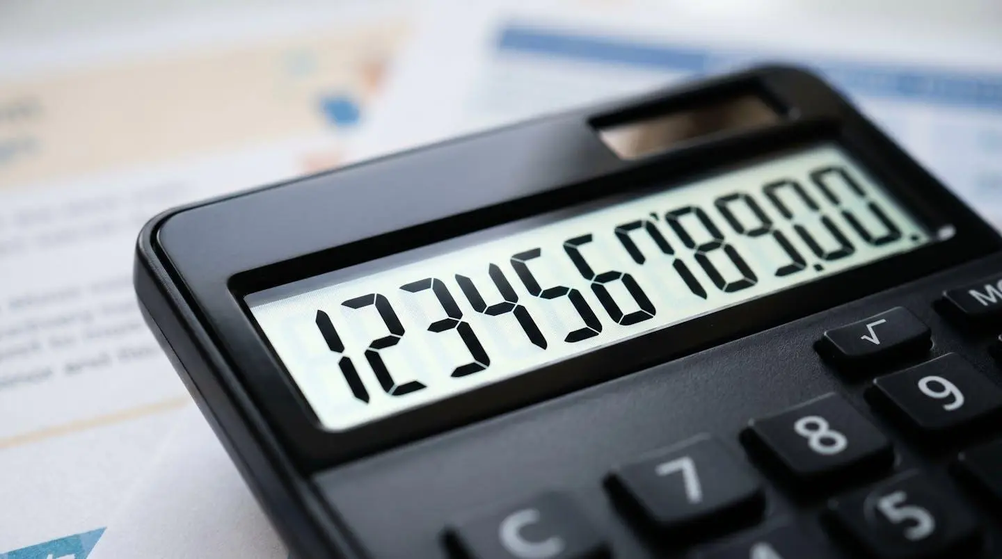 Gros plan sur une calculatrice moderne affichant des chiffres, posée sur des documents administratifs floutés